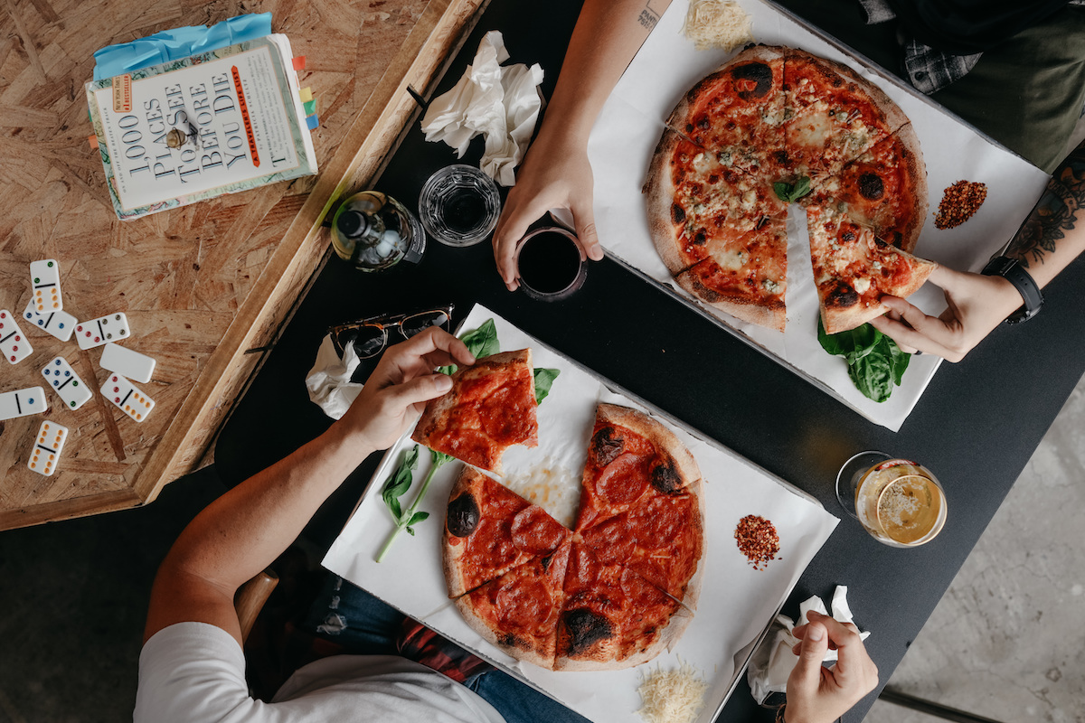 Gypsy Poet's pizzas are presented with fresh parmesan, crushed pepper, and fragrant basil. | Photo by Eugene Drake