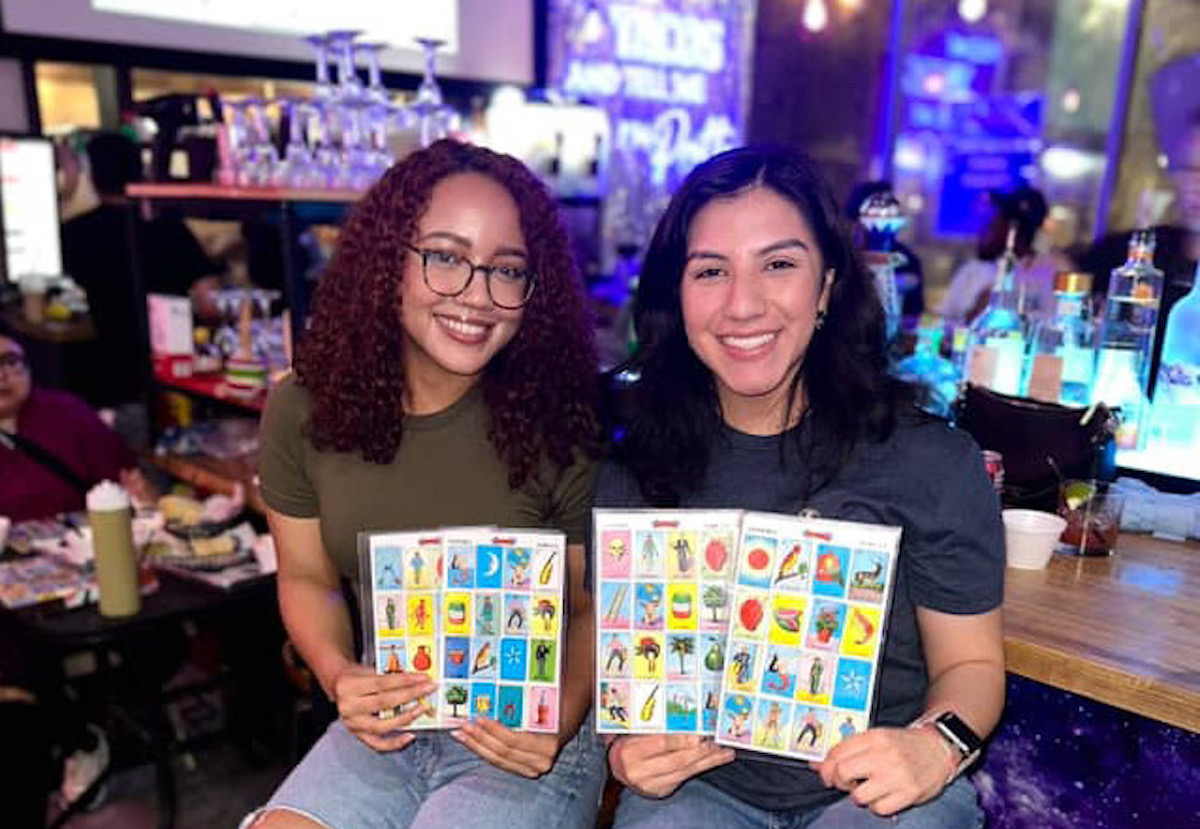 Customers pose with their loteria boards at Space City Birria. | Photo by Space City Birria
