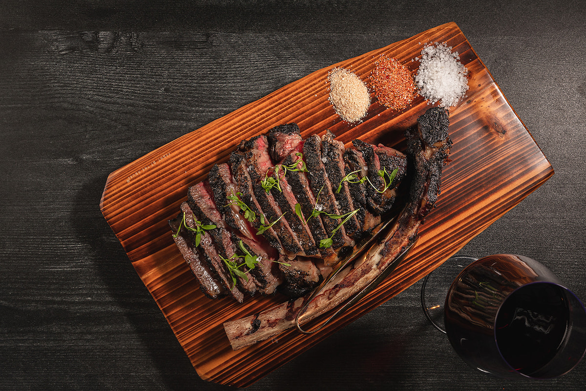 Toca Madera’s showy Flaming Tomahawk entrée is an American Wagyu Tomahawk steak treated in showmanship fashion at tableside for $325. | Photo by Toca Madera