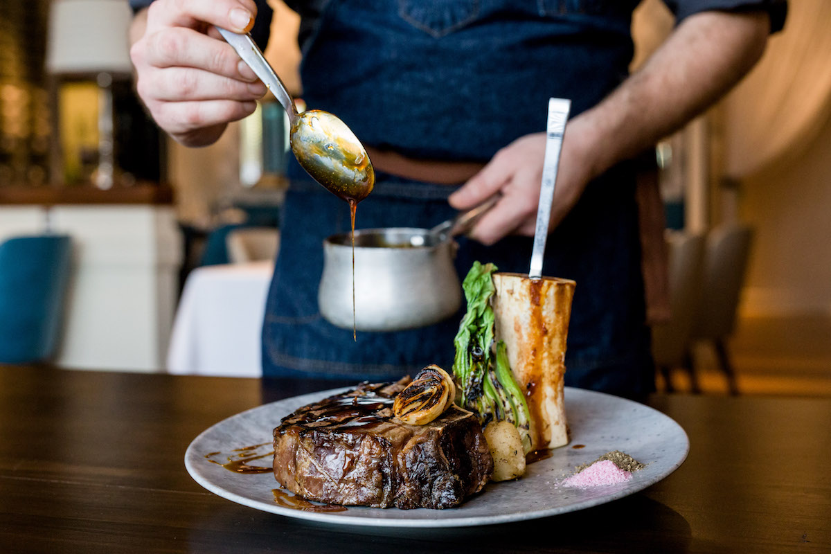 A steak at Doris Metropolitan getting its finishing touches. | Photo by Kirsten Gilliam