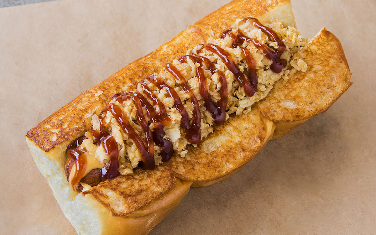 Cowboy - DiningOut Houston The Cowboy hot dog at Dog Haus, made with smoked bacon, crispy onions, and barbecue sauce. | Photo by Dog Haus
