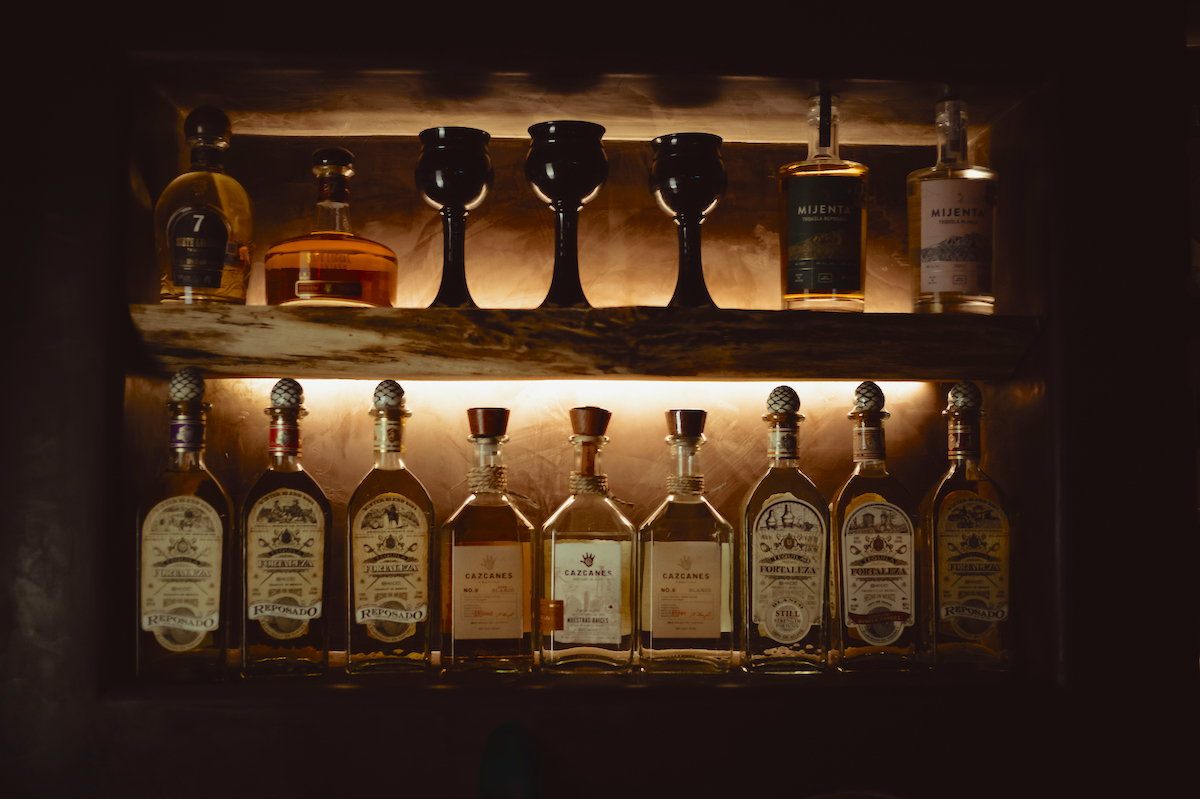 S1060821-Edit - DiningOut Houston A backlit bar showcasing agave spirits at Bar Buena. | Photo by Goode Co.
