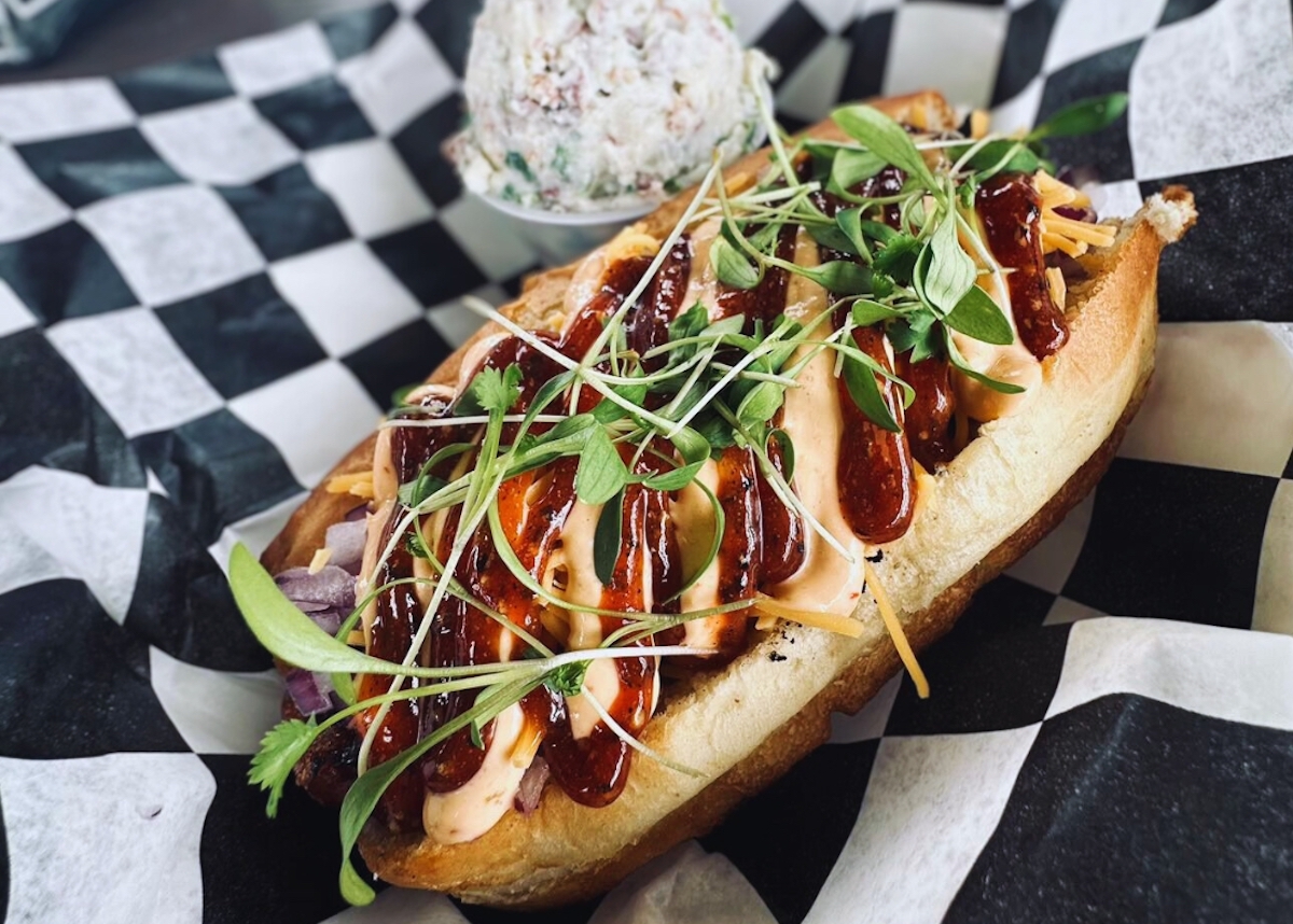 A gourmet dog at Moon Tower Inn drizzled with cheese and barbecue sauce. | Photo by Moon Tower Inn