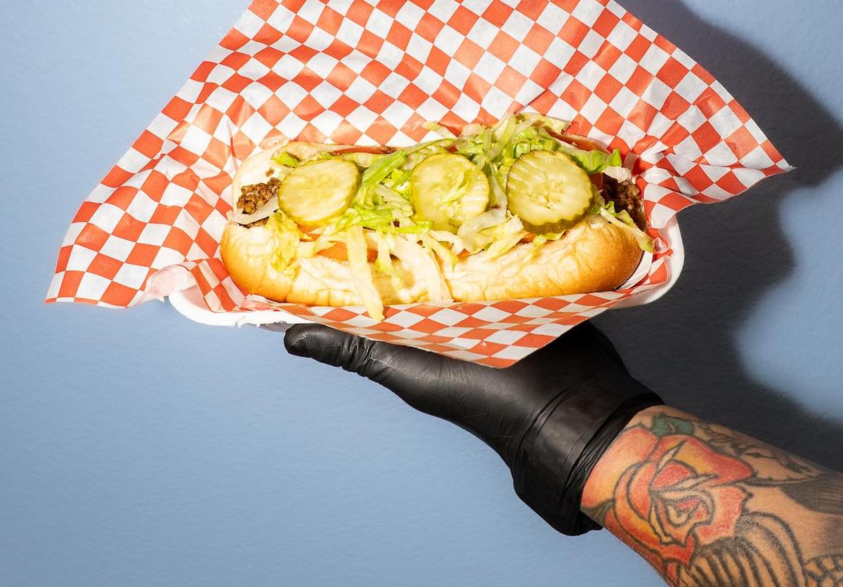 A hot dog topped with chili, lettuce, and pickles at Umbrella Fellas. | Photo by Umbrella Fellas